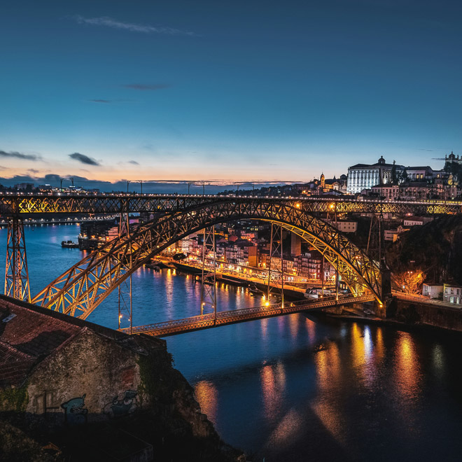 bridge over a river city scape on both sides at night