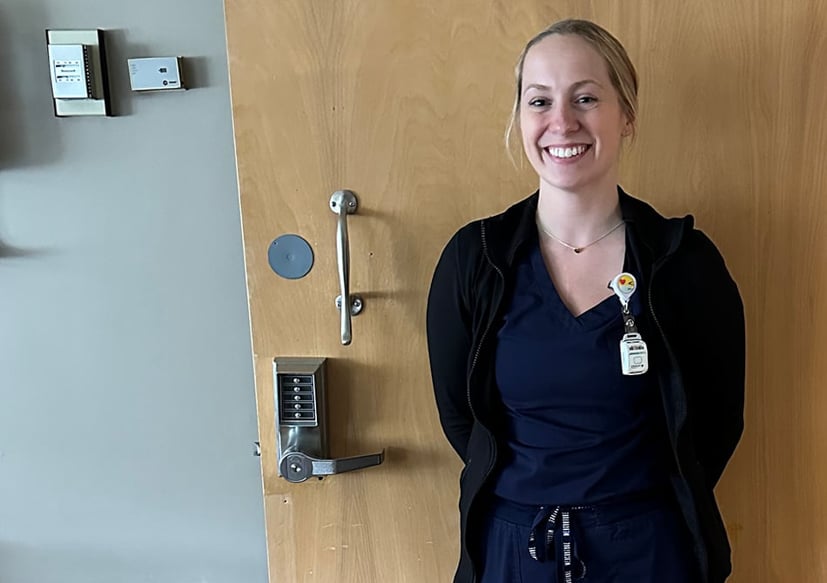Nurse standing in front of a door in the hospital.