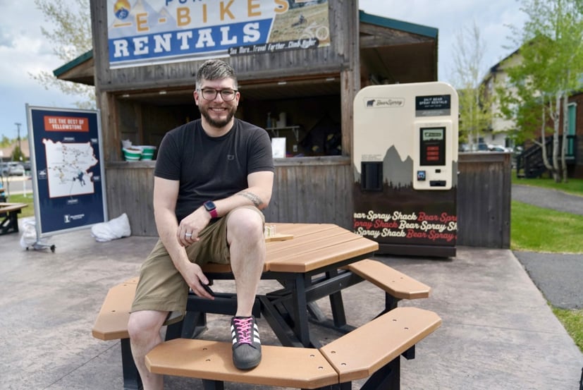 Man sitting on a picnic table outside.