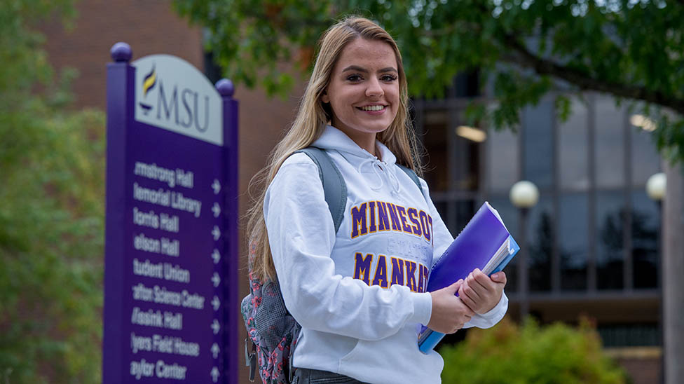 a person holding books and smiling
