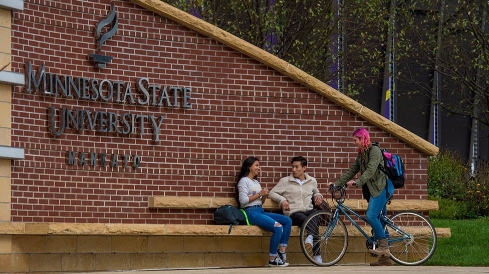 a group of people sitting on a bench outside a building