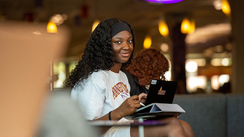 a person sitting at a table with a tablet and a pen