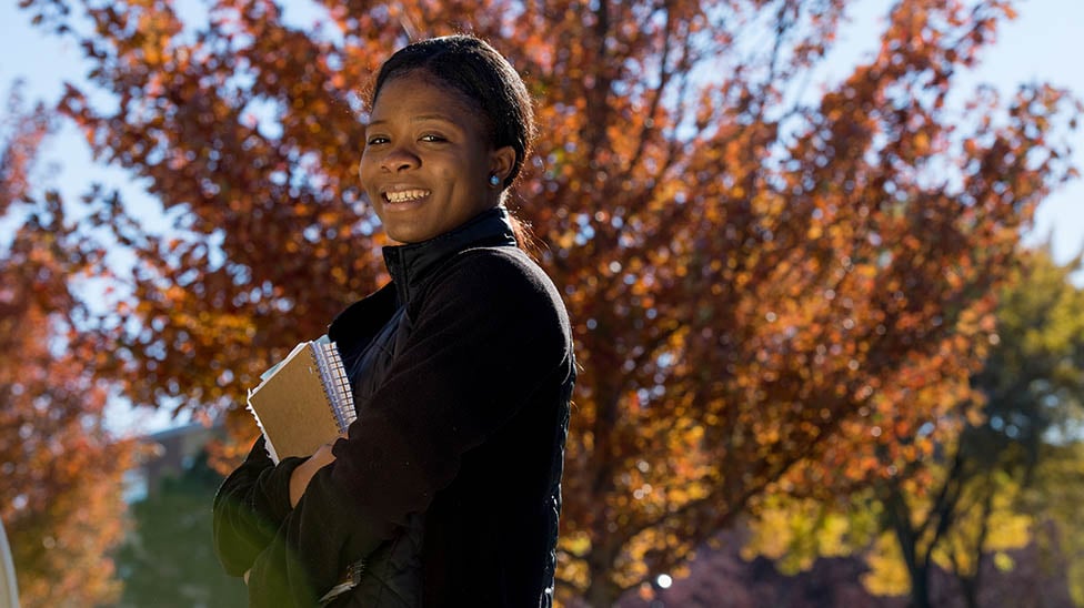 a person holding books and smiling