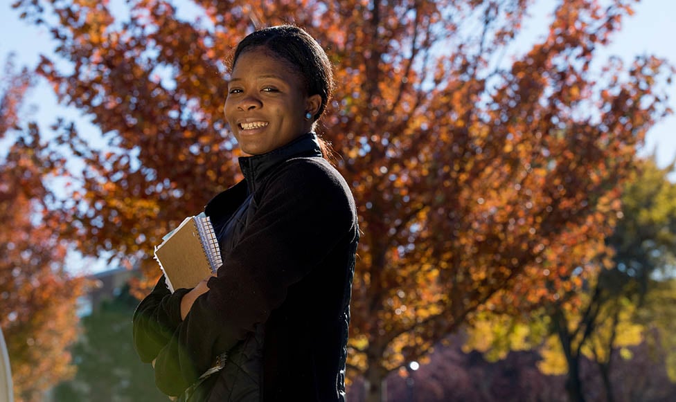 a person smiling with her arms crossed