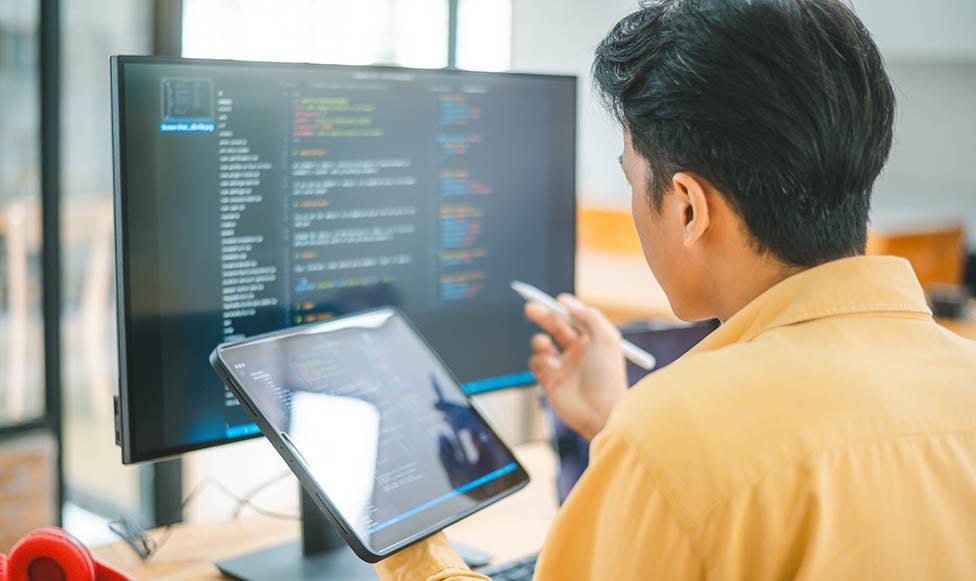student working with code on a computer at a desk