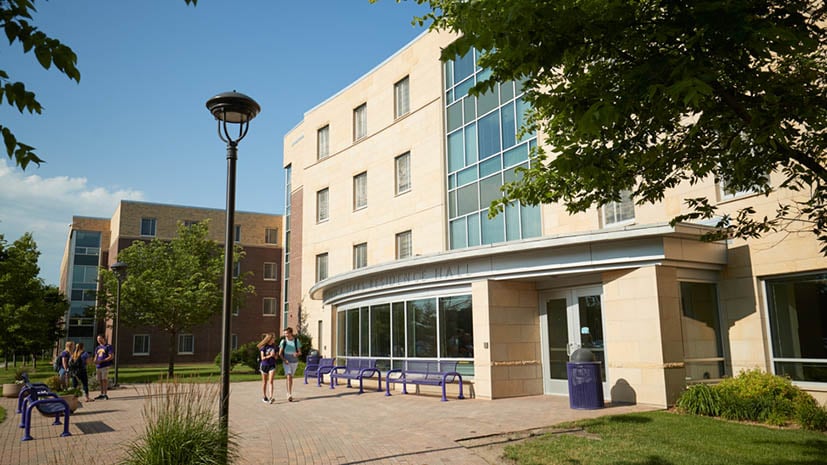 Julia Sears residence hall with students walking and talking out front