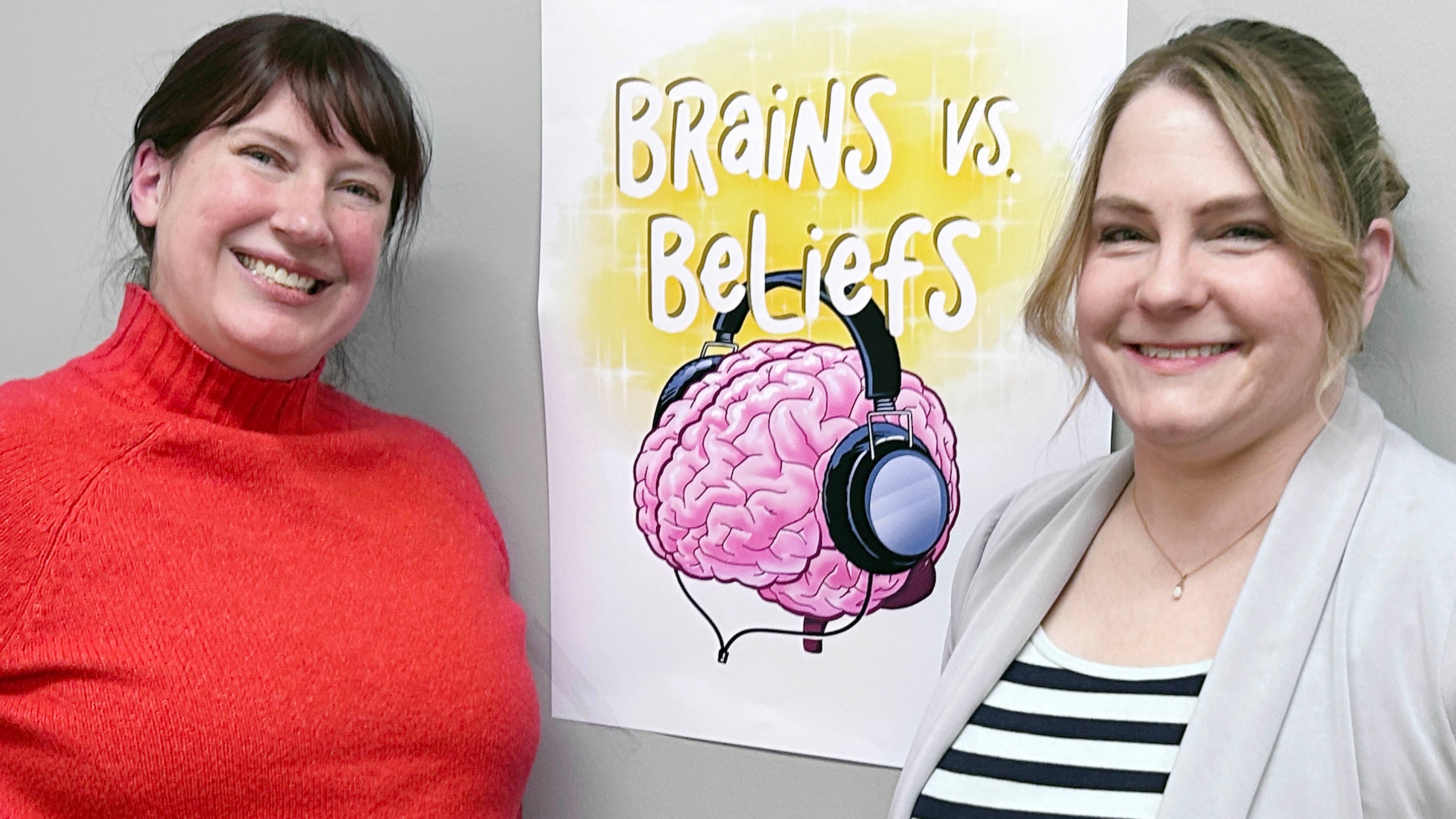Faculty members Emily Stark and Karla Lassonde next to the Brains vs Beliefs sign 