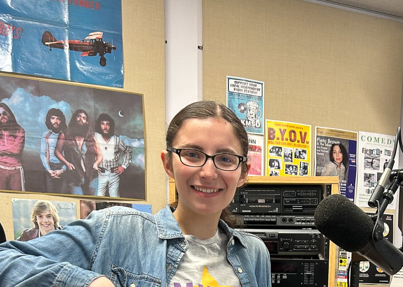 women sitting in front of radio studio equipment