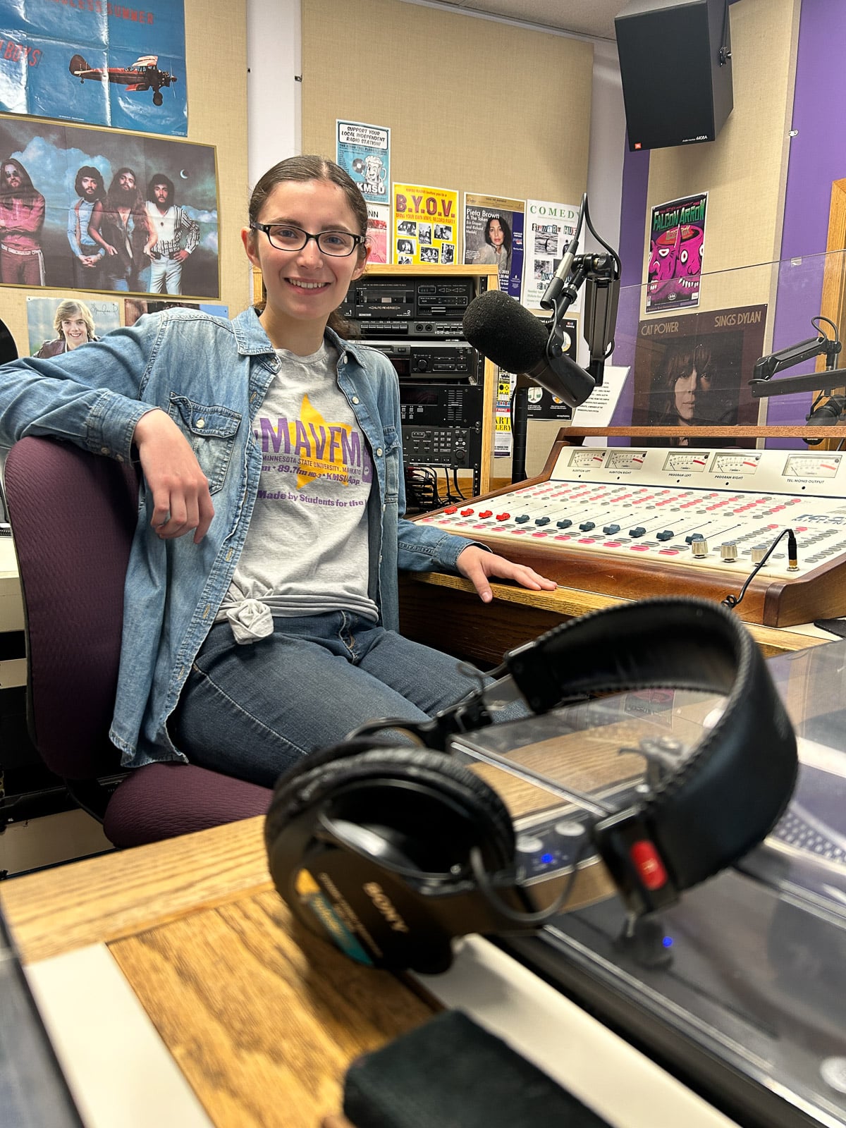 women with brown hair and glasses sitting in chair in a radio studio