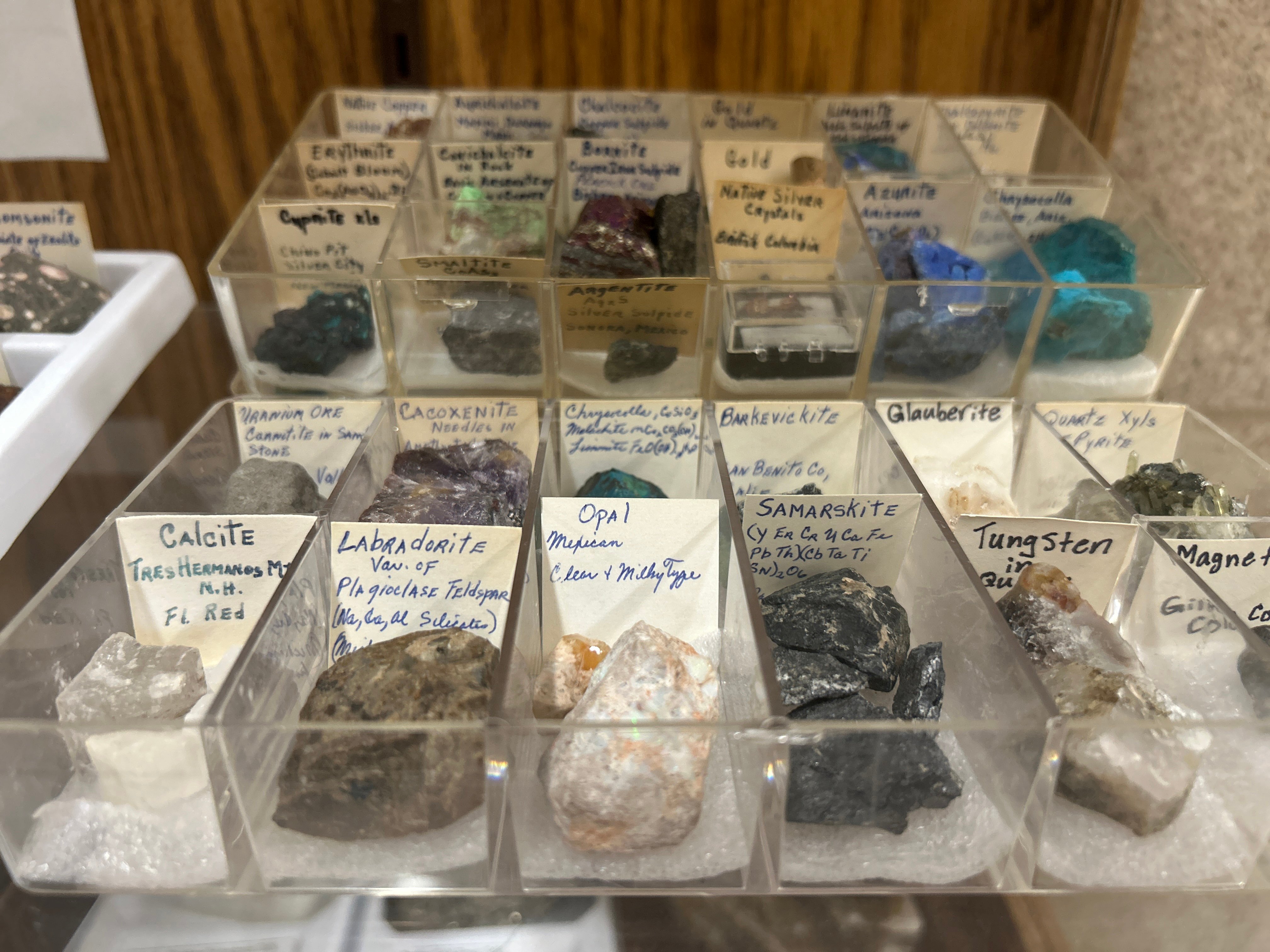 Minerals in their containers with handwritten notes naming them