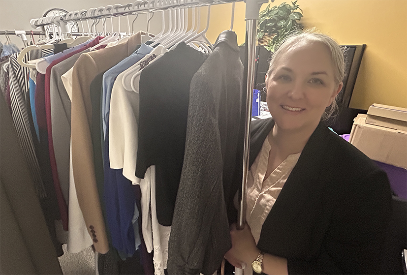 women smiling and standing by a clothing rack