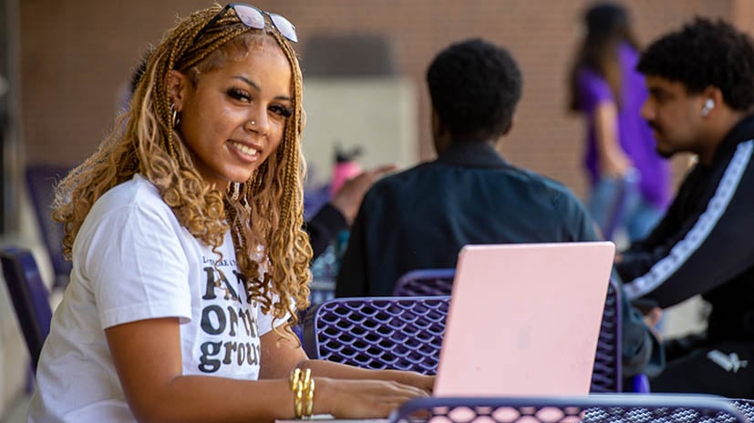 a person sitting at a table with a laptop