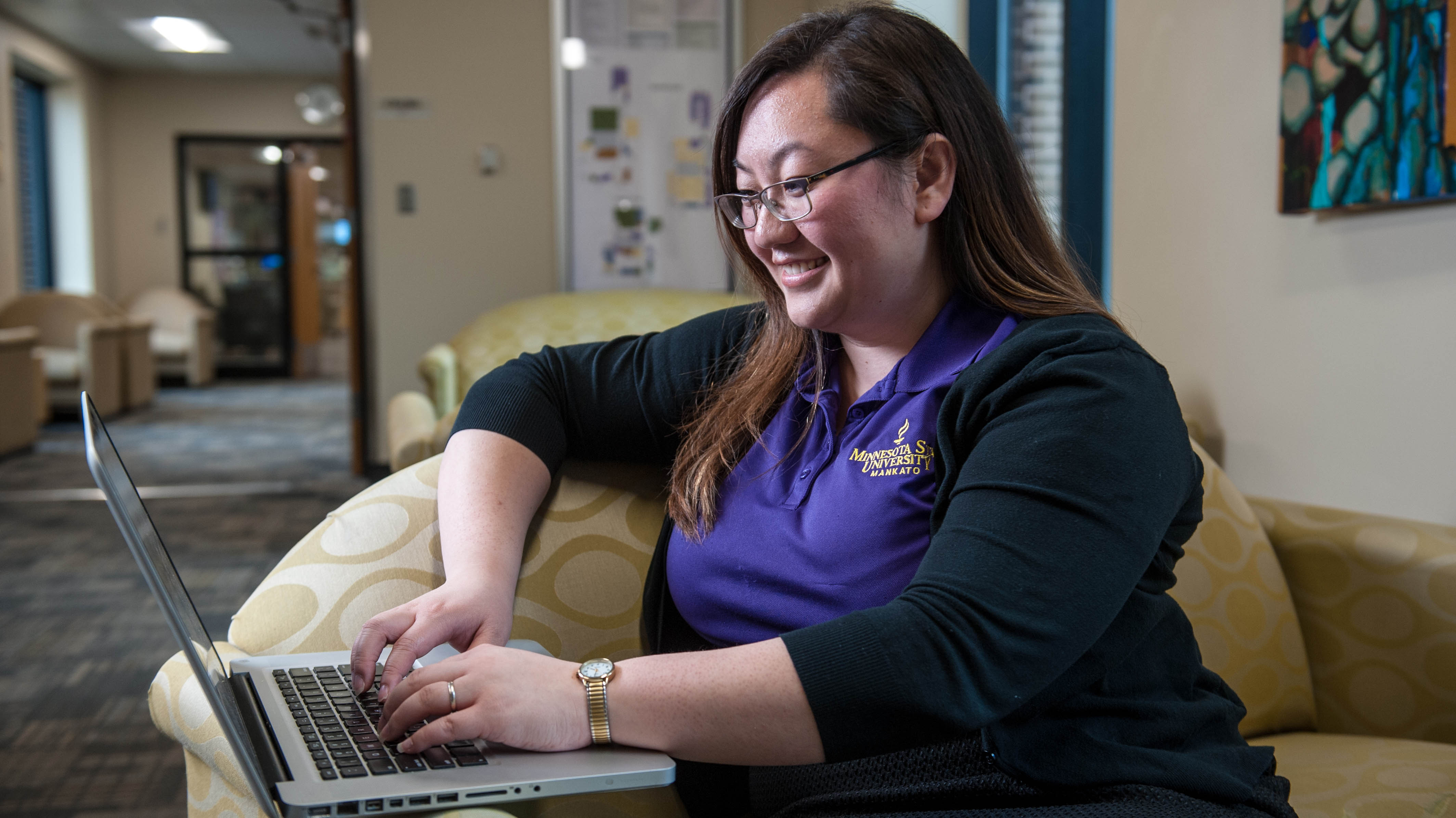 a person sitting in a chair using a laptop