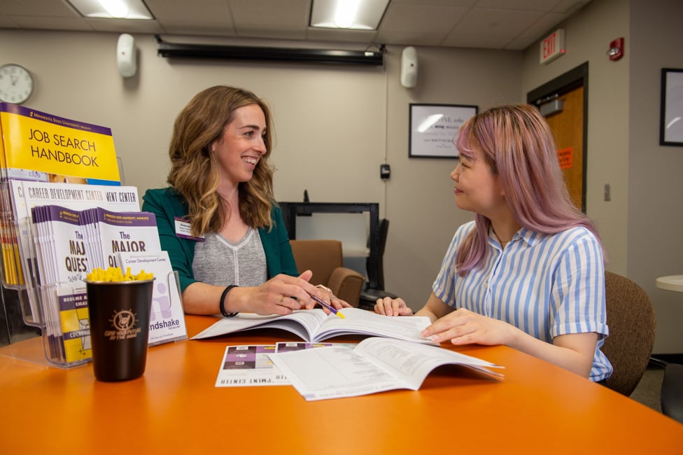 Advisor helping student in office.