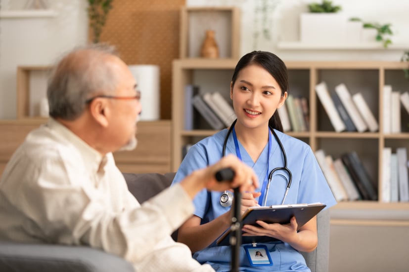 Nurse sitting down talking to patient. 