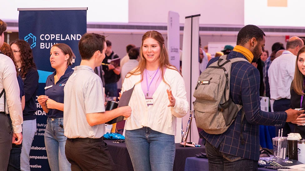 over view of a career expo with employers and students talking and networking