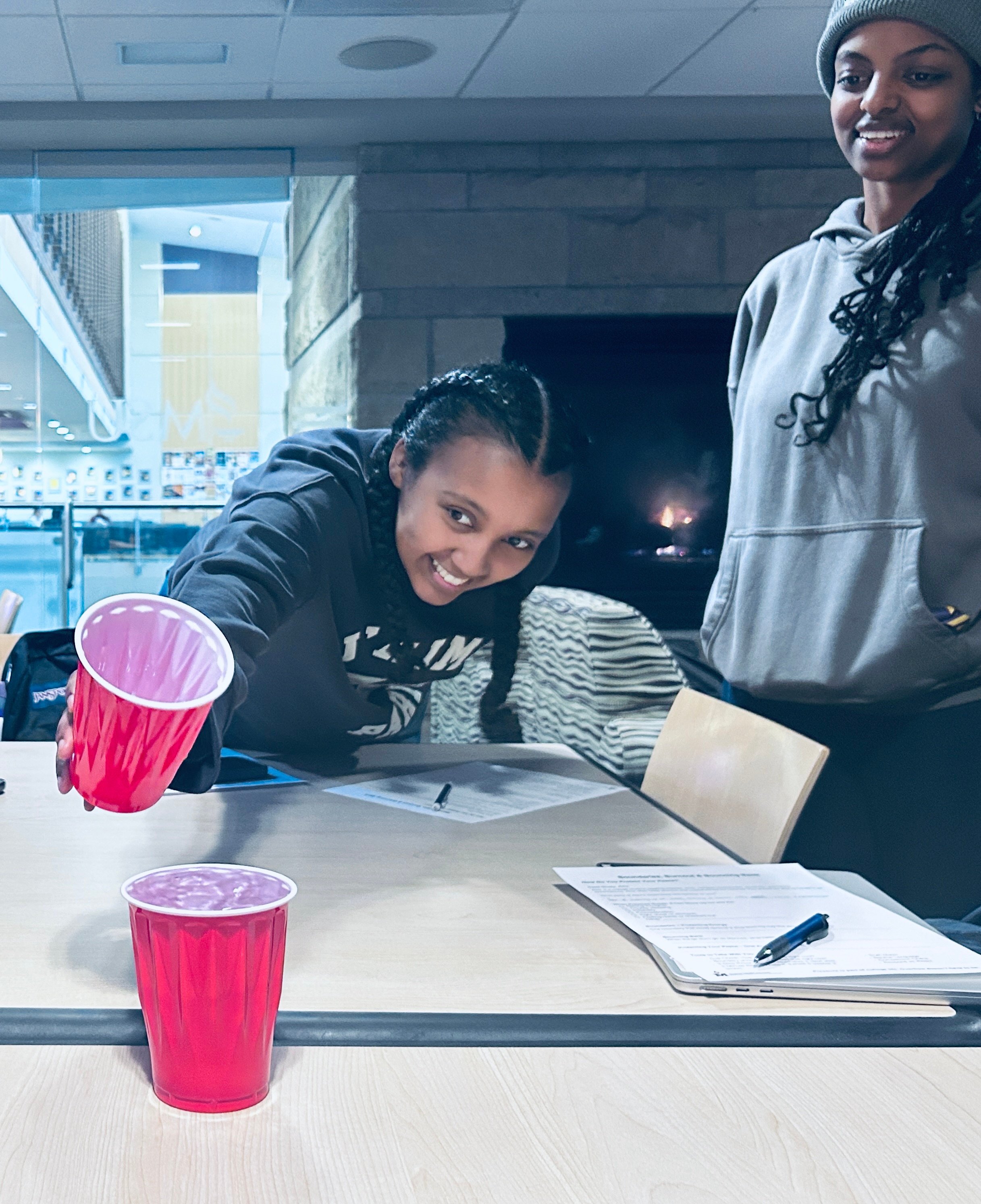 Two students filling red solo cups during a student activity.