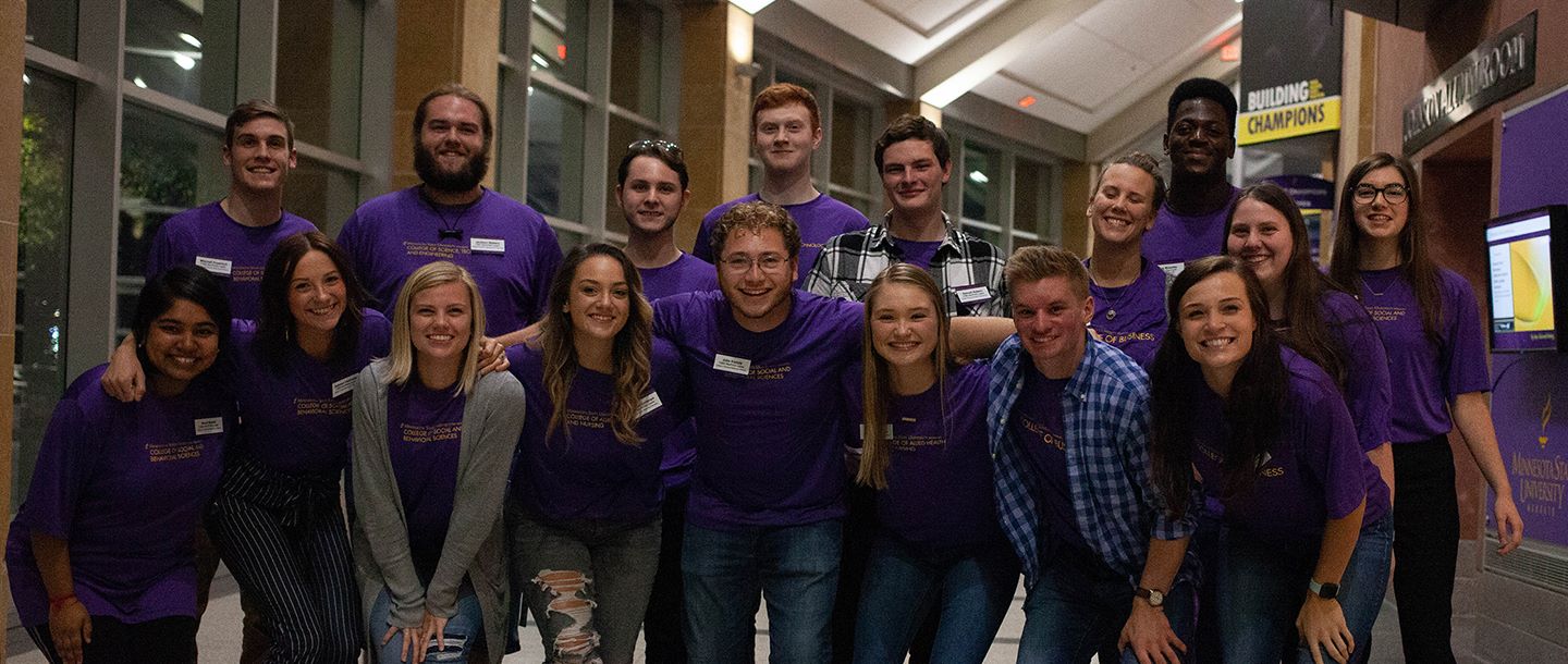 group of students posing for a picture in the hall of the Taylor Center