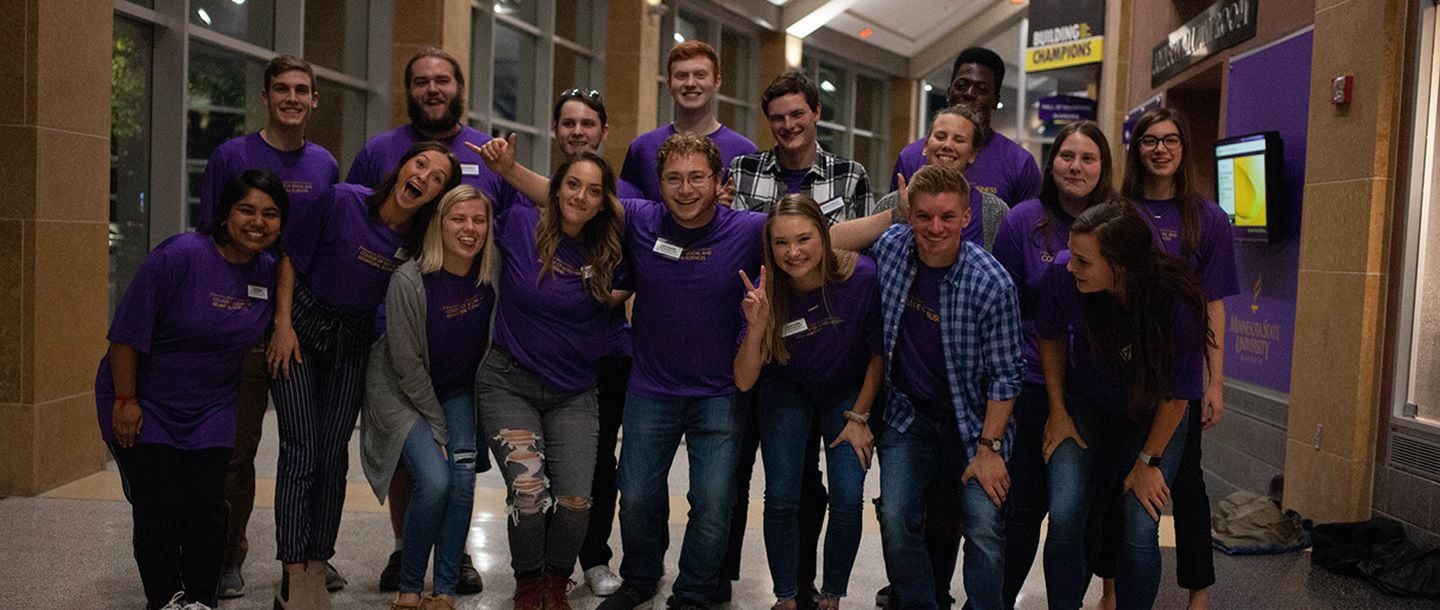 A group of students posing for a goofy photo in the hallway of Taylor Center