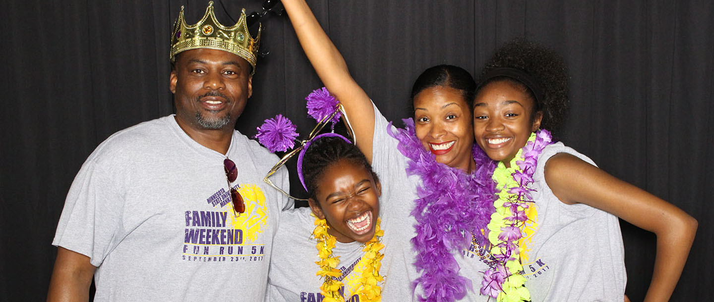 A picture of a family posing with fun props during family weekend