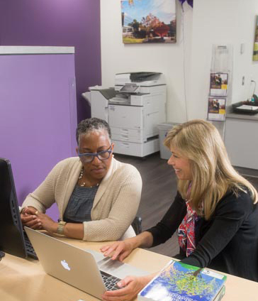 a few women looking at a laptop