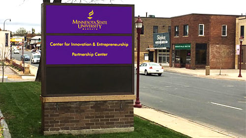 View of the Strategic Partnerships Center sign and old town Mankato in front of the Hubbard House