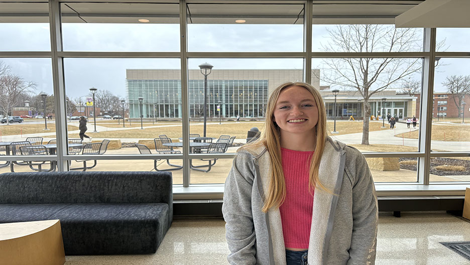 a person smiling in front of a large window