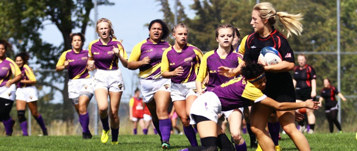 The women's wrugby team on the field during a game