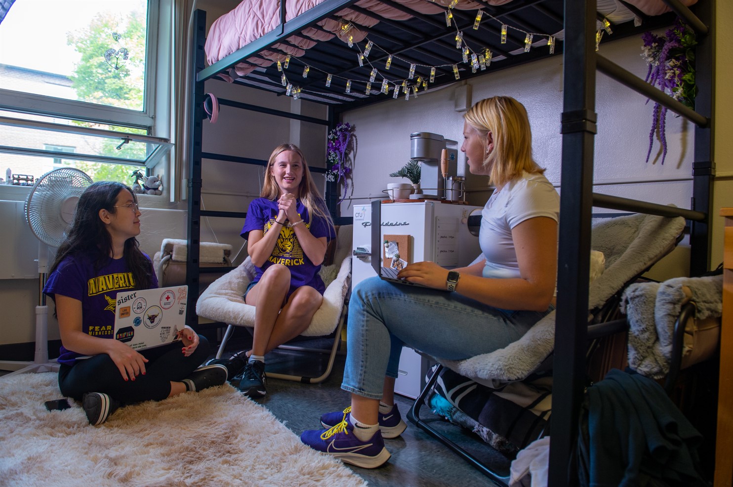 a group of women sitting in chairs and a bunk bed