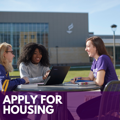 Apply for housing photo with three students sitting together at a table outside on campus and smiling