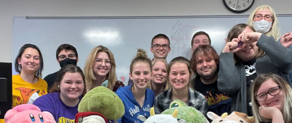 Program advisors and summer operations coordinators posing in the classroom with stuffed animals on the table