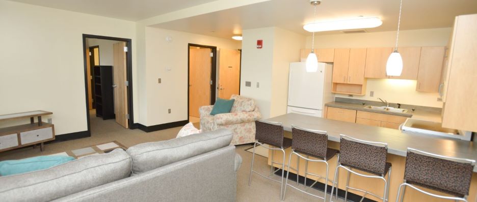 View of living room with bedroom doorway inside the JS 187 Hall Resident staff apartment