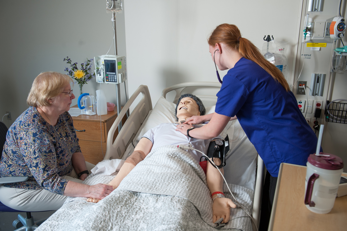 a person in a blue shirt on a personnequin in a hospital bed