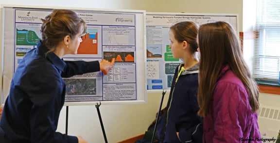 a group of people looking at a poster