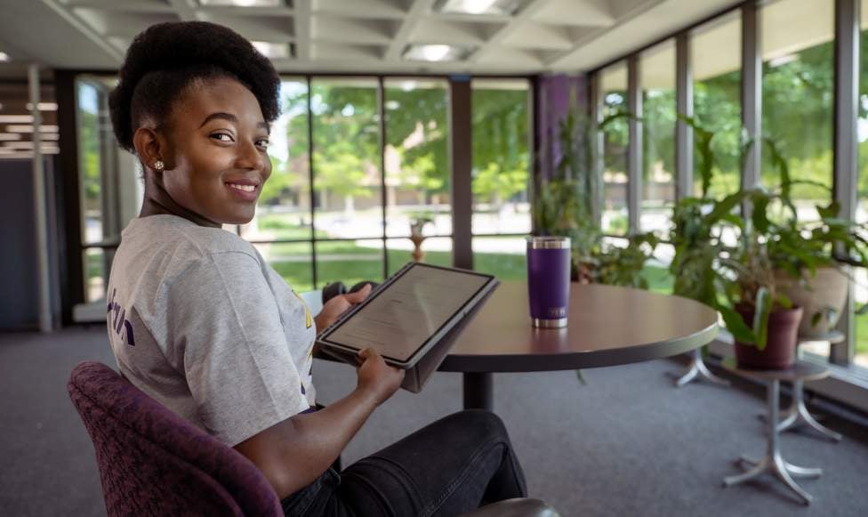 a person sitting at a table holding a tablet